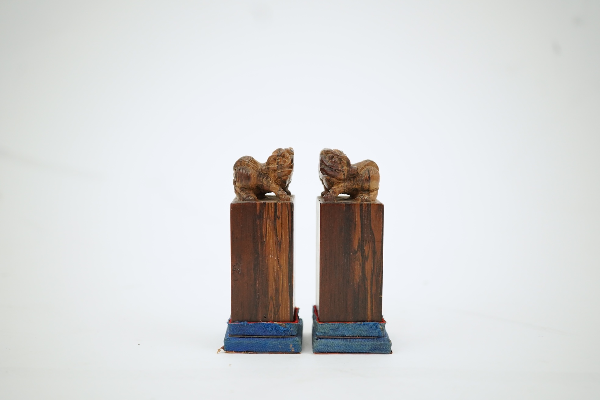 A cased pair of Chinese hardwood ‘lion-dog’ seals, early 20th century